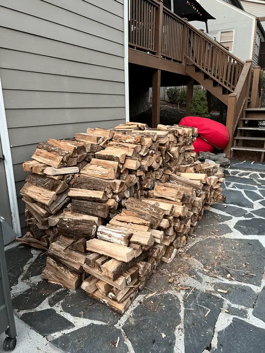Firewood on a flagstone patio beside deck stairs