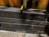 Stacked landscape timbers forming a low retaining wall
